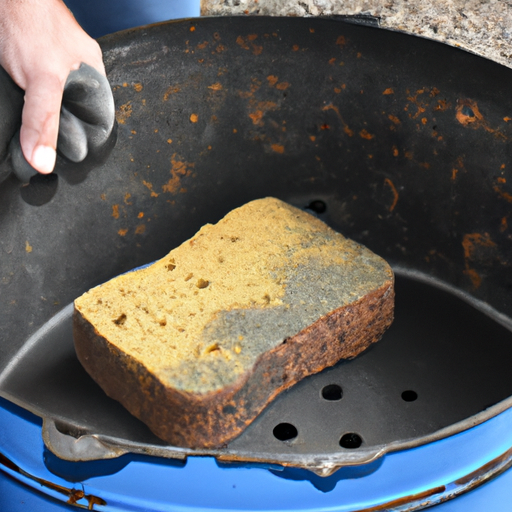 A person scrubbing a dutch oven with a non-abrasive sponge.